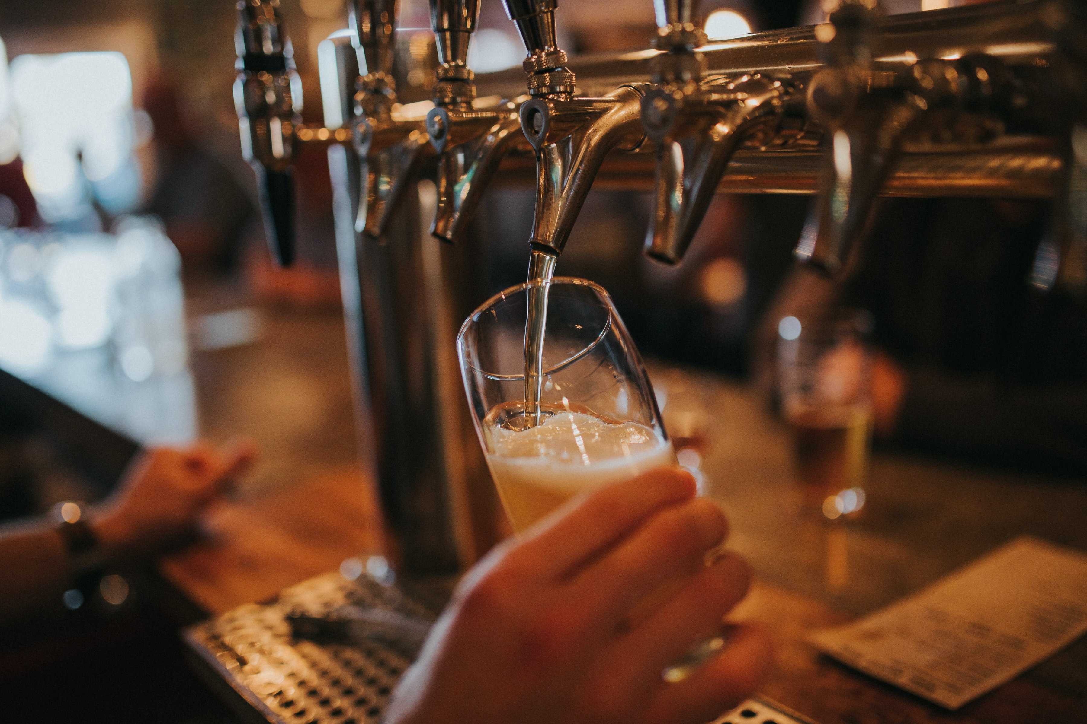 A glass being filled with beer from a tap